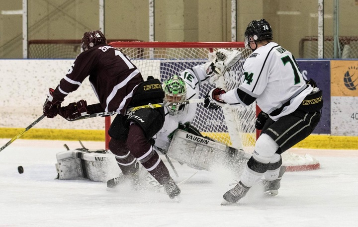 Mike Salmon (31) makes 1 of his 21 saves as Austin Hunter (74) ties up the Griffins forward. Photo - Tony Hansen